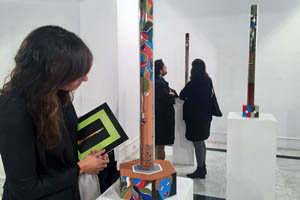 Una joven observa los minuciosos detalles de una de las obras de Pilar Santos realizados con pluma sobre acrílico