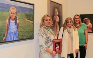 La artista con sus hijas y los cuadros de cuando eran pequeñas