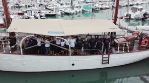 La tripulación posa en el barco atracado en el puerto de Les Minimes.