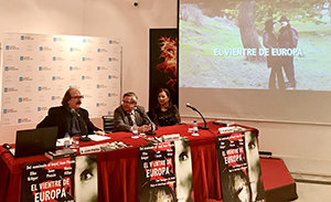 2. En la mesa, de izquierda a derecha, el director Juan Pinzás, el coordinador de Actos Ramón Jiménez y la productora Pilar Sueiro con una imagen del trailes de la película EL VIENTRE DE EUROPA.jpg