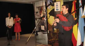 El profesor de música del Centro Galicia interpreta el himno gallego. De fondo, Emilia García, representantes del Arquivo Galego da Emigración, y Luisa, integrante de la Delegación de la Xunta en Argentina.