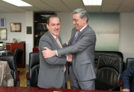 Agustín Torres saluda al representante de la UNED tras la firma del convenio.