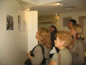 Un grupo de personas visitan la muestra fotográfica el día de su inauguración.