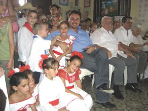 Moisés Plasencia rodeado de niños con el traje típico en su reciente visita a Cuba.