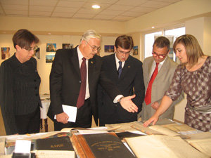 Fernando Bosch guía a la comitiva del Gobierno en su recorrido por la muestra de fotos y libros.
