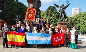 Directivos, autoridades consulares y la reina de la Casa regional posan ante el monumento al General San Martín.