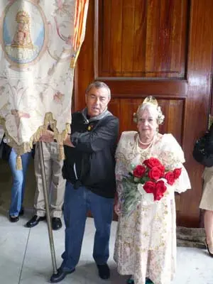 El presidente de Asoval, Felipe Sáez, porta el estandarte de la ‘Geperudeta’, junto a Carmen Deltell, quien viste de fallera a sus 80 años.