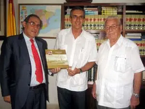 Pablo Barrios muestra a Machín el ‘Libro de Oro’ del Hogar Canario de Cuba, en presencia de Carmelo González.