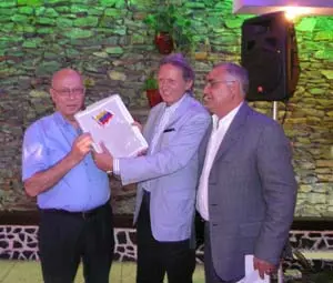  José Matres recibe el reconocimiento de manos del secretario y del presidente del CRE de Venezuela.