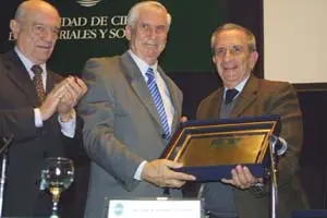 Sánchez Naveros recibe la distinción de manos del rector de la UCES, Juan Carlos Barinaga, y el profesor Jorge Alonso.