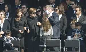 Carlos Mouriño, acompañado por sus nietos, su nuera, su mujer y su hija, besa la bandera de México que cubrió el feretro de su hijo.
