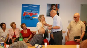 El alcalde de Baleira, Francisco Acal, le regala un bolígrafo a una paisana de 90 años presente en el acto.