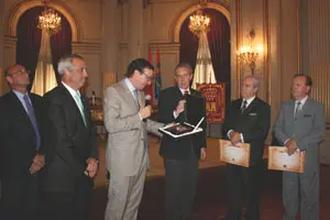 El diputado Gerardo Ingaramo recibe de José María Castillo una placa recordatoria.