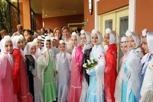 Victoria Cristóbal posa con las niñas que lucen los vestidos llevados desde Madrid.