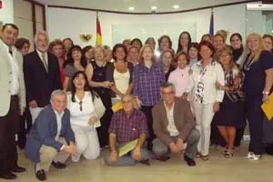 El consejero de Trabajo, el jefe de Gestión de la Consejería de Trabajo e Inmigración, Junta Directiva de la FEDED, así como representantes de las asociaciones, posan junto a las 22 nuevas cuidadoras.