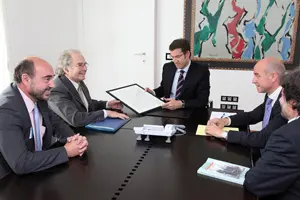 Esquivel hace entrega del dibujo a Feijóo en presencia de Luis Vaamonde, director de ‘Galicia en el Mundo’.