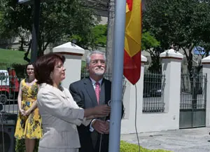 Pilar Pin iza la bandera de España durante el acto solemne.
