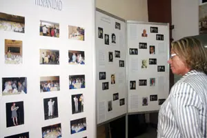 La presidenta de la Diputación observa un mural sobre la emigración de Castilla y León.