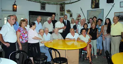 El delegado de la Xunta posa con los miembros de Zas, en la sede de la instituci&oacute;n en el barrio de La Boca.