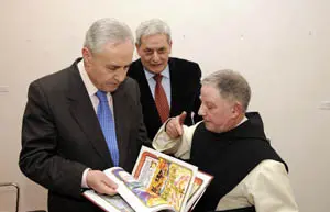 Fray Luis, monje de Oseira, muestra un ejemplar al director de la Casa de Galicia en Madrid, José Ramón Ónega, en presencia de su antecesor en el cargo, Alfonso S. Palomares.