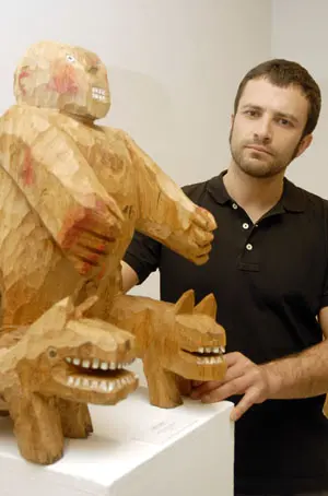 El escultor con su obra ‘Paseo de bestias’, en madera policromada.