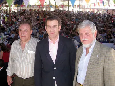  Feijoo, acompañado por Luis Piñeiro y Manuel Alabart, posa con el impresionante aspecto de la romería detrás.