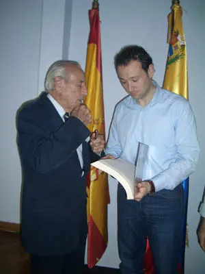 Oliverio Alas Fernández, fundador del CAC y encargado de la biblioteca de la entidad, regala un libro a Guillermo Martínez Suárez.