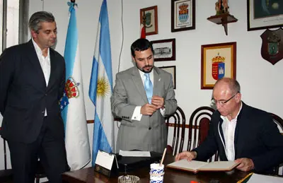  Camba -acompa&ntilde;ado de Santos Gast&oacute;n y Alejandro L&oacute;pez- lee la dedicatoria que dej&oacute; en el libro de visitantes. 