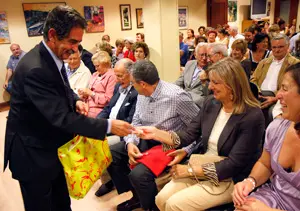 El presidente c&aacute;ntabro entrega pulseras del A&ntilde;o Jacobeo a los asistentes. 