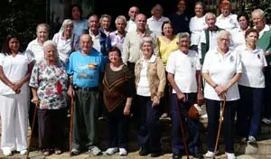 El presidente y la primera dama del CAC, posan ante la réplica de la ‘Cueva de la Santina’, junto a los beneficiarios del ‘Centro de Día’, y parte del personal que atiende a estas personas de la tercera edad. 