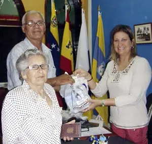 Jenny Capllonch Calderón –a la dcha.– hace entrega de los medicamentos a dos beneficiarios.