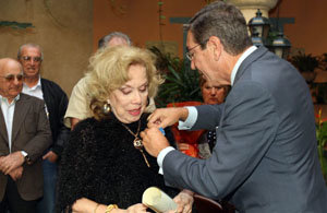 Manuel Cacho le coloca la medalla de la Orden del Mérito Civil a Rosita Fornés.