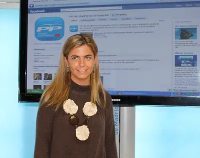 La responsable del PP de Madrid en el Exterior posa con la pantalla donde se ve la nueva página en facebook.
