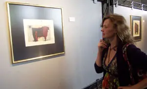 Una mujer contempla uno de los cuadros que componen la exposición.