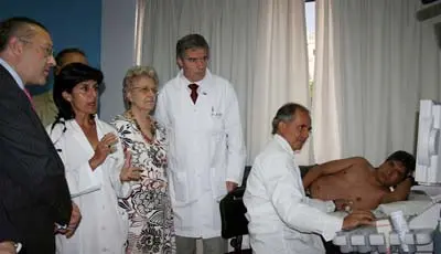 La responsable médica del servicio explica al director general el funcionamiento de la aparatología, mientras se le realiza un estudio demostrativo a un voluntario para la prueba.