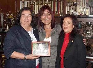 Guillermina Hernández Martín, recibe una fotografía conmemorativa del HCV, de manos de la otrora presidenta de la entidad, Arcilia Díaz González, en compañía de la directora general de la Ciudadanía Española en el Exterior, Pilar Pin Vega,