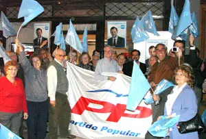Afiliados al PP de España en Argentina enarbolan las banderas del partido en la noche de la pegada de carteles.