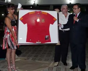 Richard Barreiro y Olmedo, cónsul honorario –dcha.–, entrega la camiseta de la selección absoluta al CGPLC, que es recibida por el presidente, Manuel Sinde Porto, ayudado por Daisy Mocharrachif.