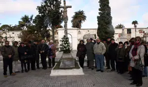 Los asistentes, junto a la ofrenda floral en el cruceiro. 