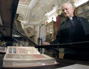 El deán José María Díaz observa una edición facsímil del Códice Calixtino, expuesta en una sala de la catedral, de cuyo archivo ha desaparecido la obra original.