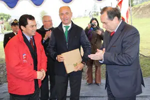 El gobernador de Chiloé, Cesar Zambrano, (I) y Camba (c) entregan un presente al alcalde de Chiloé Nelson Aguilar.