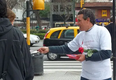 Uno de los voluntarios reparte flores y folletos, en Buenos Aires.