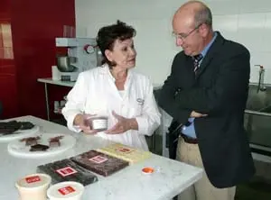  La directora de la Escuela KKO Real explica al consejero de Trabajo e Inmigraci&oacute;n los diferentes productos logrados en la escuela.