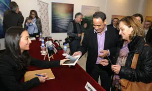 María Canosa firma ejemplares de su libro a algunos de los asistentes.
