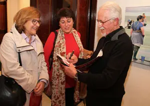 El pintor firmando catálogo