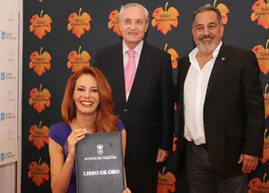 Paula muestra el libro de oro de la Casa donde Pelaez y ella acaban de firmar invitados por el delegado de la Xunta José Ramón Ónega