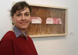 Isabel Somoza ante su obra de puños realizados por xilografía, aguafuerte y grabado matérico