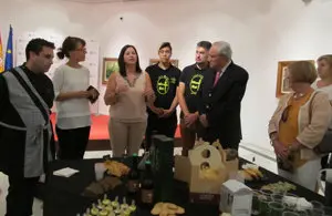 El delegado de la Xunta, José Ramón Ónega, y parte del público siguen algunas explicaciones de los promotores del acto sobre sus productos