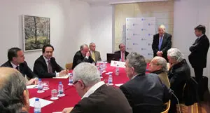 El delegado dela Xunta en Madrid, José Ramón Ónega, se dirige a los parpticipantes en la reunión acompañado por  Víctor Cortizo (a su izda.) y Javier Serra (a su dcha.)