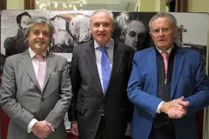 Esteban Meruéndano, el delegado de la Xunta, José Ramón Ónega, y Rodríguez Iglesias posan ante un panel con imágenes del libro